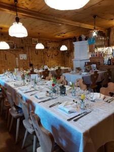 einen langen Tisch in einem Zimmer mit weißen Tischen und Stühlen in der Unterkunft Hotel Crusch Alba Sta Maria in Sta Maria Val Müstair