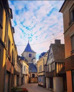 una calle de la ciudad con edificios y un castillo en el fondo en Côté Château en Gaillon