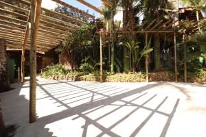 a shadow of a pergola on a patio at Pousada Maria Bonita in Macacos