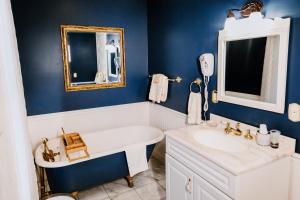 ein Badezimmer mit einer weißen Badewanne und einem Waschbecken in der Unterkunft 1897 Beekman House Bed and Breakfast in Dundee