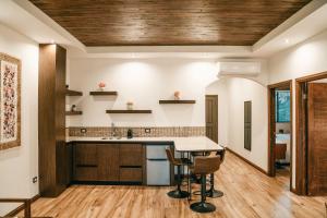 Il comprend une cuisine avec des plafonds en bois, une table et des chaises. dans l'établissement Villa Montefiori, à Valle de Guadalupe