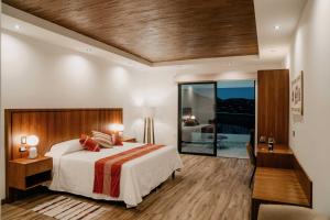 um quarto com uma cama grande e uma porta de vidro deslizante em Villa Montefiori em Valle de Guadalupe