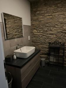 a bathroom with a sink and a stone wall at Ferienwohnung am Wald-und Wiesenkorb in Kell