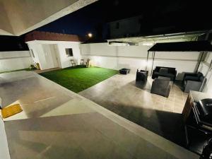 an empty patio at night with chairs and a green yard at The VIlla DUBAI in Dubai