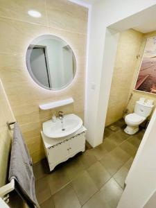 een badkamer met een wastafel, een toilet en een spiegel bij The VIlla DUBAI in Dubai