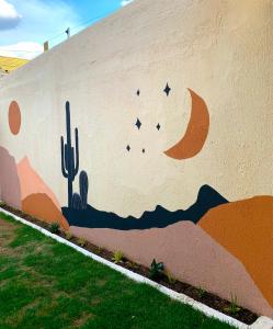 un mural junto a una pared con cactus en Casa Sóumi - Ubajara/CE, en Ubajara