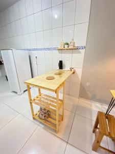 a small table in a kitchen with a refrigerator at Casa Sóumi - Ubajara/CE in Ubajara