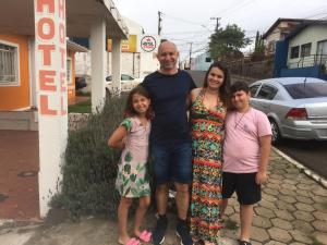 Ein Mann und seine beiden Töchter posieren für ein Bild. in der Unterkunft Hotel Pousaria in Guarapuava