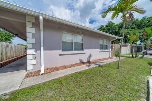 a house with a palm tree in front of it at Modern home 10 minutes from Fort Lauderdale beach! in Fort Lauderdale