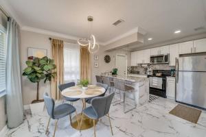 a kitchen with a table and chairs and a refrigerator at Modern home 10 minutes from Fort Lauderdale beach! in Fort Lauderdale