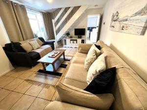 un soggiorno con divano e tavolo di Anchor Cottage - beautiful two bedroom cottage in the heart of Holt a Holt