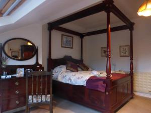 a bedroom with a canopy bed and a dresser at Sally End in Ravenstonedale