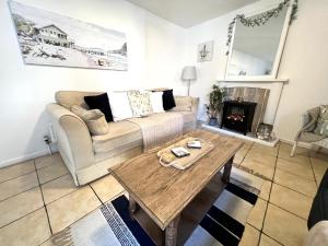 a living room with a couch and a table at Anchor Cottage - beautiful two bedroom cottage in the heart of Holt in Holt
