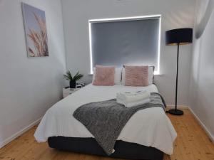 - une chambre avec un grand lit et des oreillers roses dans l'établissement Portland sea spa retreat, à Portland
