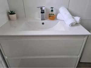 - un lavabo blanc dans la salle de bains avec des serviettes. dans l'établissement Portland sea spa retreat, à Portland