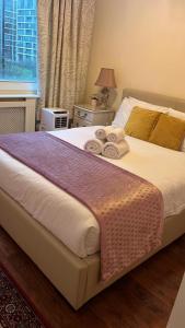 a bedroom with a bed with towels on it at Lovely 3 bedroom apartment in London