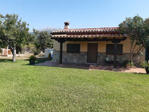 a small house with a green lawn in front of it at La Celestina in Candeleda