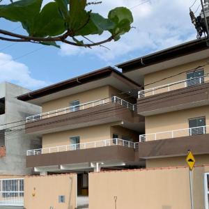 - un bâtiment avec des balcons sur le côté dans l'établissement Apartamento aconchegante em frente à praia., à Ubatuba