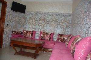 un soggiorno con divano rosa e tavolo di Ozoud high standing appartment a Ouzoud