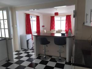 una cocina con suelo a cuadros en blanco y negro en Simon's Place is a 3 bedroom bungalow in H.T.H en Jamestown