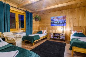 um quarto com 2 camas num quarto com paredes de madeira em Apartament Stryszek Alpinistyczny em Bukowina Tatrzańska