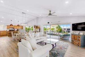 a living room with white furniture and a kitchen at Plaza Del Sol in Islamorada