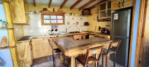 a kitchen with a wooden table and a refrigerator at Casa Jardín de Hadas con Vista Panorámica in Pisco Elqui +18 photos