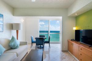 a living room with a couch and a table with a view at Club Regina Cancun in Cancún