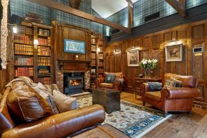 a living room with leather furniture and a fireplace at Carriage House 1884 in Crafers