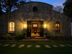 a stone house at night with lights at Carriage House 1884 in Crafers