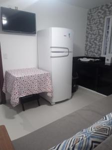um frigorífico branco num quarto com uma mesa em Casas Bérgamo em Morro de São Paulo