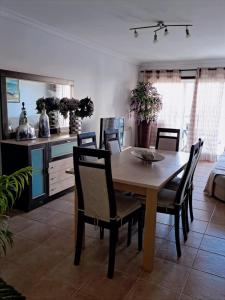 a dining room with a wooden table and chairs at Apartamento Mar e Sol in Gafanha da Nazaré