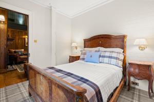 ein Schlafzimmer mit einem Holzbett mit einem blauen Kissen in der Unterkunft Carriage House 1884 in Crafers
