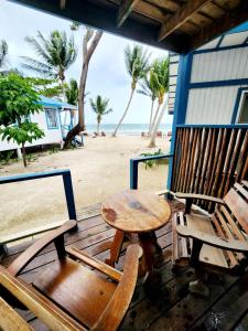 una mesa y sillas sentadas en una terraza con la playa en Maya Beach Hotel, en Maya Beach
