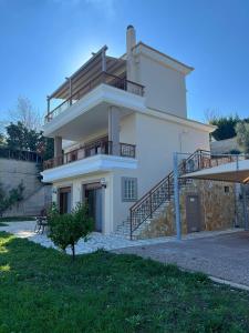 a large white house with a balcony and stairs at VillaAriadniNafplion in Nafplio