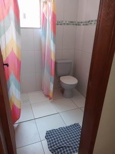 a bathroom with a toilet and a shower curtain at Pousada do Chileno in Praia Grande