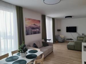 uma sala de estar com um sofá e uma mesa em Apartman X12, Hillside em Dolný Kubín