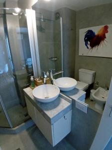 a bathroom with two sinks and a shower and a toilet at Apartamento Nueva Córdoba in Cordoba