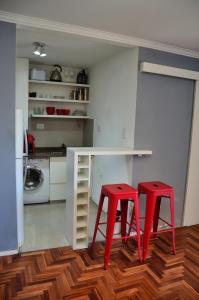 a kitchen with two red stools and a white table at Apartamento Nueva Córdoba in Cordoba