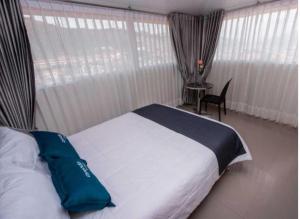 Un dormitorio con una cama con una almohada azul. en Hotel Luna de Oro Cusco, en Cusco