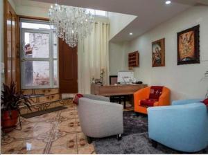 a living room with chairs and a table and a chandelier at Hotel Luna de Oro Cusco in Cusco