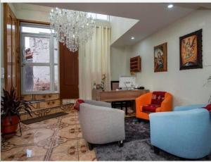 a living room with a couch and chairs and a desk at Hotel Luna de Oro Cusco in Cusco