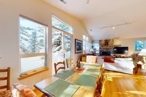 a dining room with a table and a living room at Green Pine in Sun Valley
