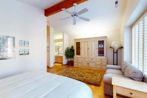 um quarto com uma cama, um sofá e uma ventoinha de tecto em Green Pine em Sun Valley