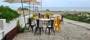 eine Gruppe von Tischen und Stühlen mit einem Schirm in der Unterkunft BDA Hotel & Spa in Punta del Este