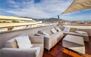 a balcony with couches and a view of a city at Lovely Apartment In Las Lagunas De Mijas With Kitchen in Fuengirola