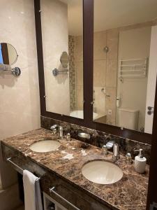 a bathroom with two sinks and a large mirror at Privilege Apart hotel Mountain Village in Canela