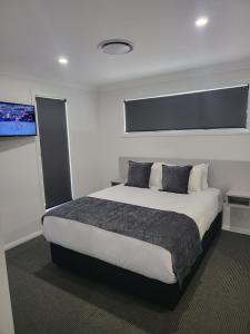 a bedroom with a large bed and a flat screen tv at CH Boutique Apartments The Ringers Road in Tamworth
