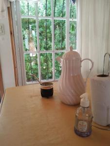 a table with a jug and a bowl on a table with a window at Cabañas El Labriego in Malargüe