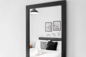 einen Spiegel vor einem Schlafzimmer mit einem Bett in der Unterkunft Vibrant 1 Bedroom Cosy Apartment - City Centre in Birmingham